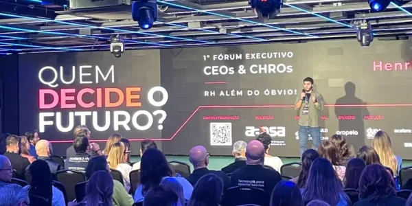 Henrique Calandra no palco do 1º Fórum Executivo CEOs & CHROs da AAPSA, diante do telão com a pergunta Quem decide o futuro?
